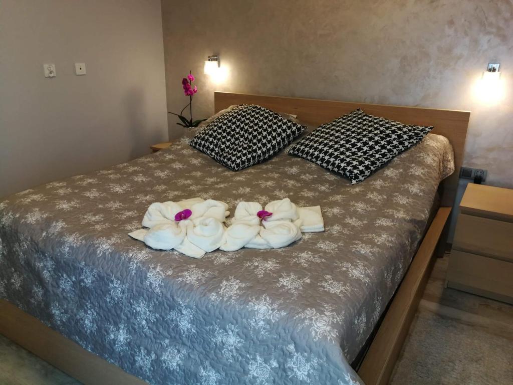 a bed with three towels on top of it at Coral SPA Apartament Pięć Mórz in Sianozety