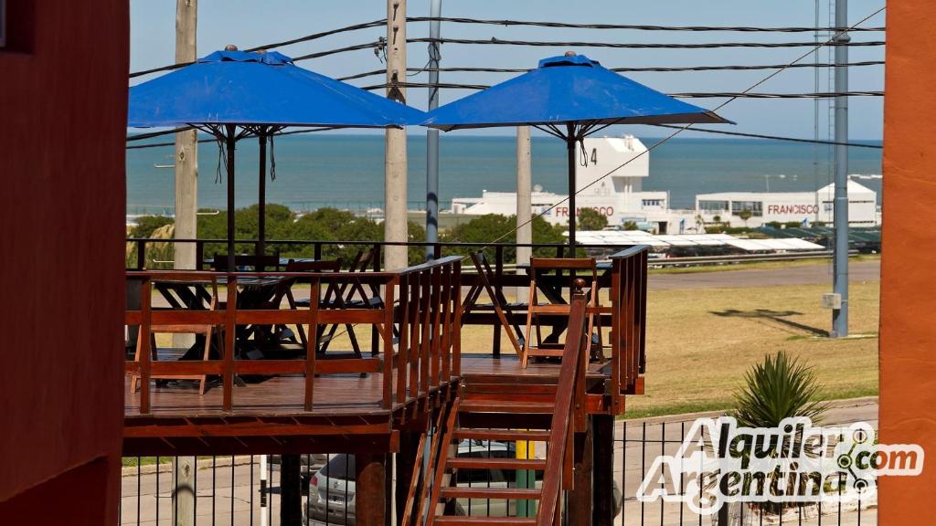 a table with two blue umbrellas on a deck at Vista al Mar Punta Mogotes in Mar del Plata