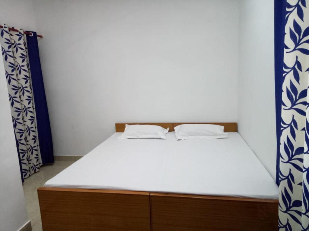 a bed with two pillows on it in a room at vinyaka p.g.house in Rāmnagar