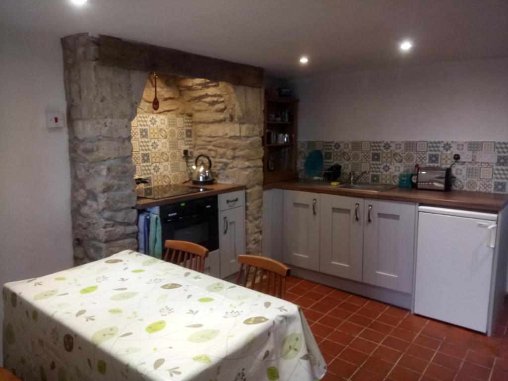 una cocina con mesa y mantel. en The Old Swan walkers cottage en Bath