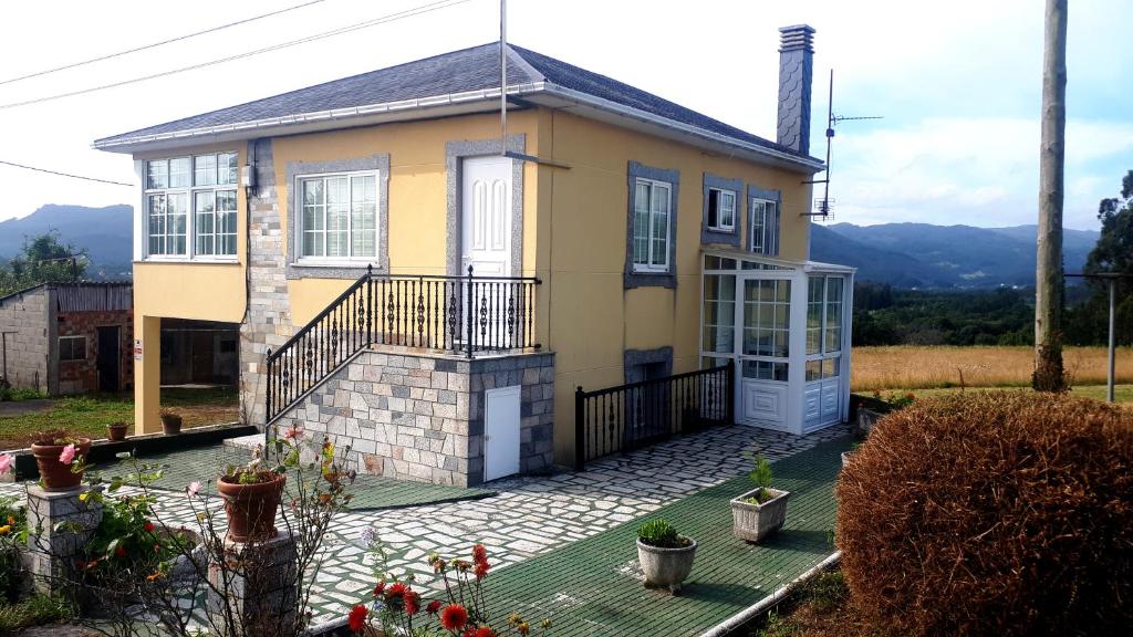 a yellow house with a porch and a balcony at CASA PUMARES in Lagoa