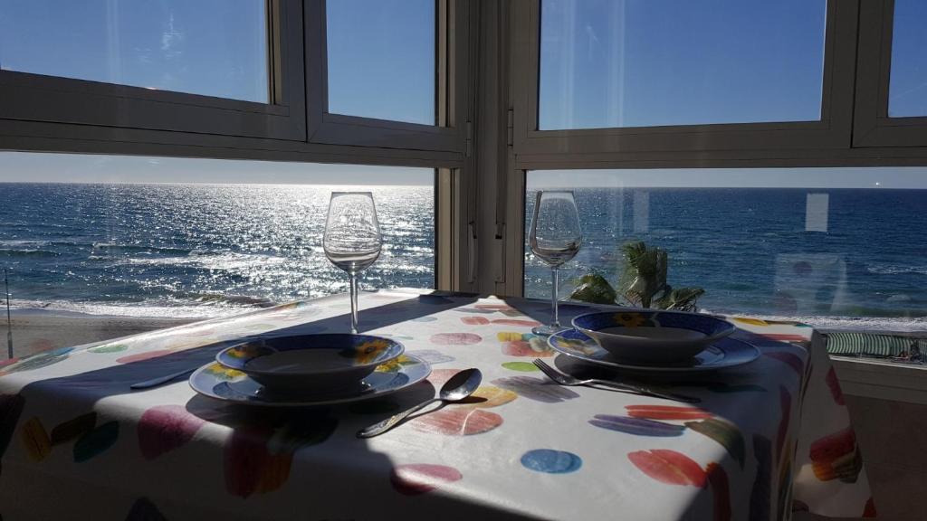 stół z 2 kieliszkami do wina i stół z widokiem na ocean w obiekcie Beachfront 82 w mieście Torrox Costa