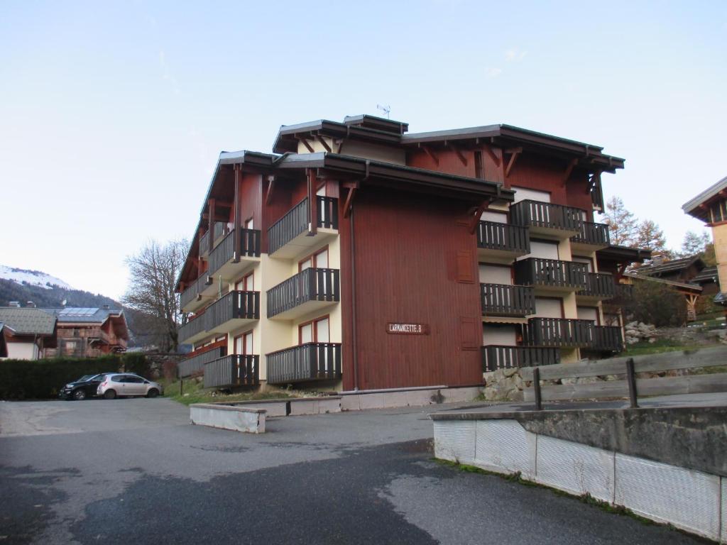un edificio con un estacionamiento delante de él en appartement 4 personnes Armancette en Les Contamines-Montjoie