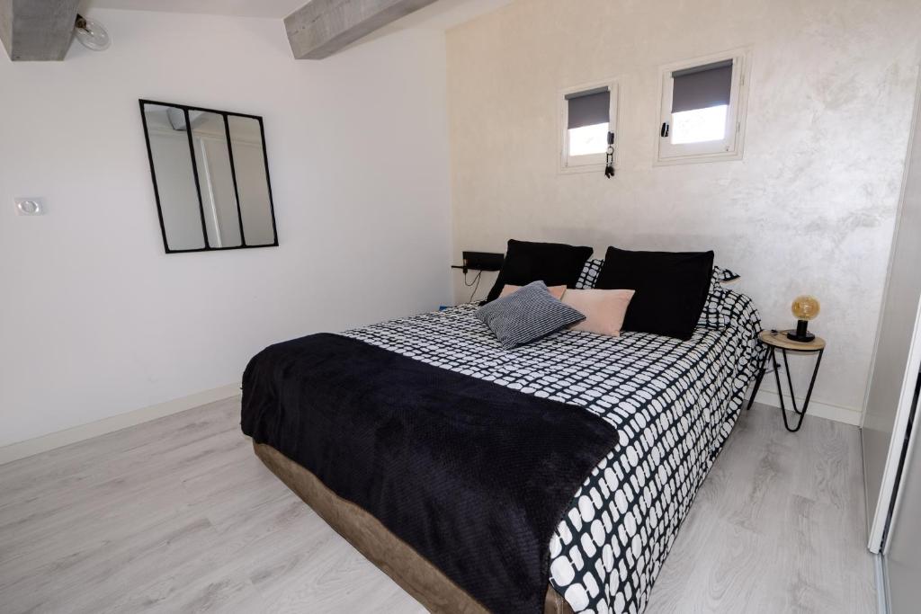 1 dormitorio con 1 cama grande con manta blanca y negra en A 2 pas de la Mer en Sausset-les-Pins