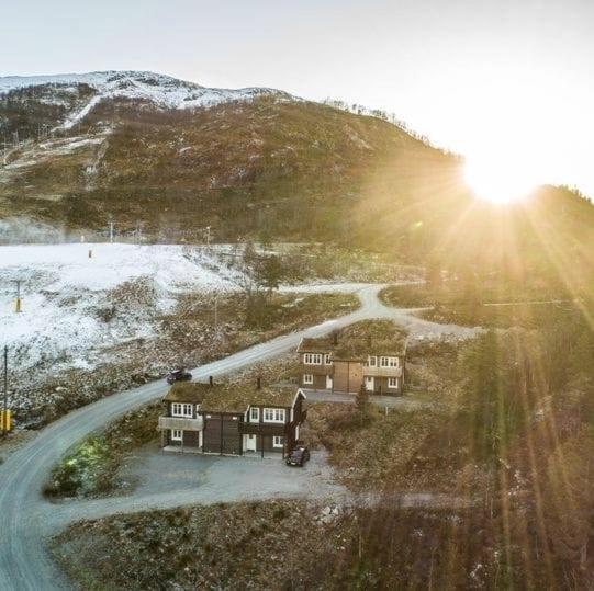 een huis aan de zijkant van een heuvel met een weg bij Bjørkelia Lodge in Vassenden