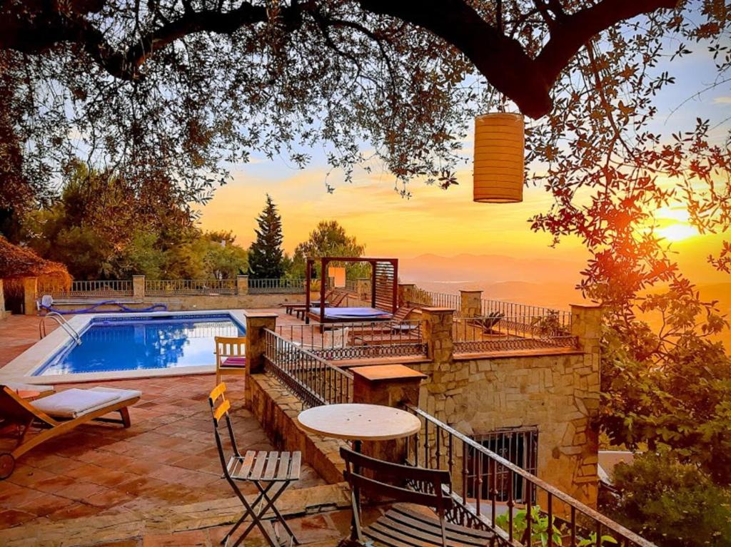 un patio trasero con piscina, mesa y sillas en El Nispero Dulce, en Alcaucín