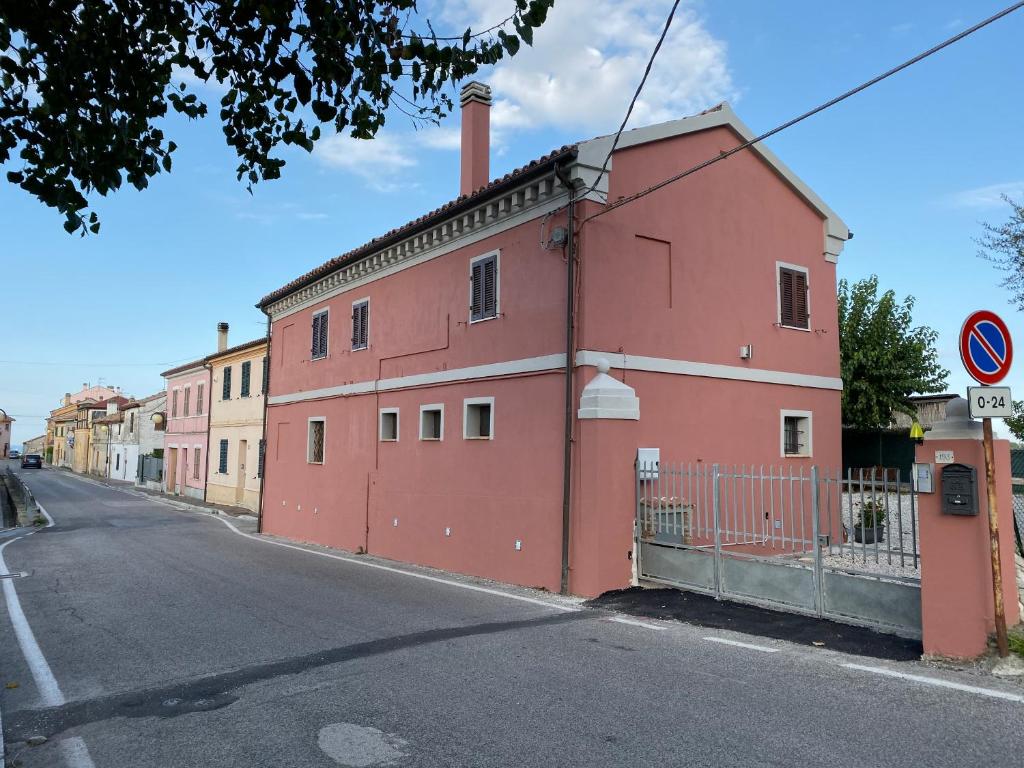 um edifício vermelho no lado de uma rua em B&B La Grancia em Chiaravalle