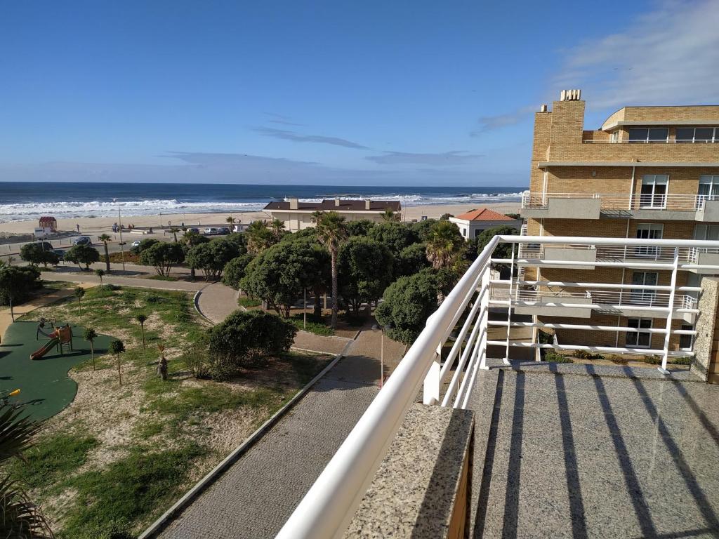 a balcony with a view of the beach and a building at Sun, Sky and Sea in Esmoriz