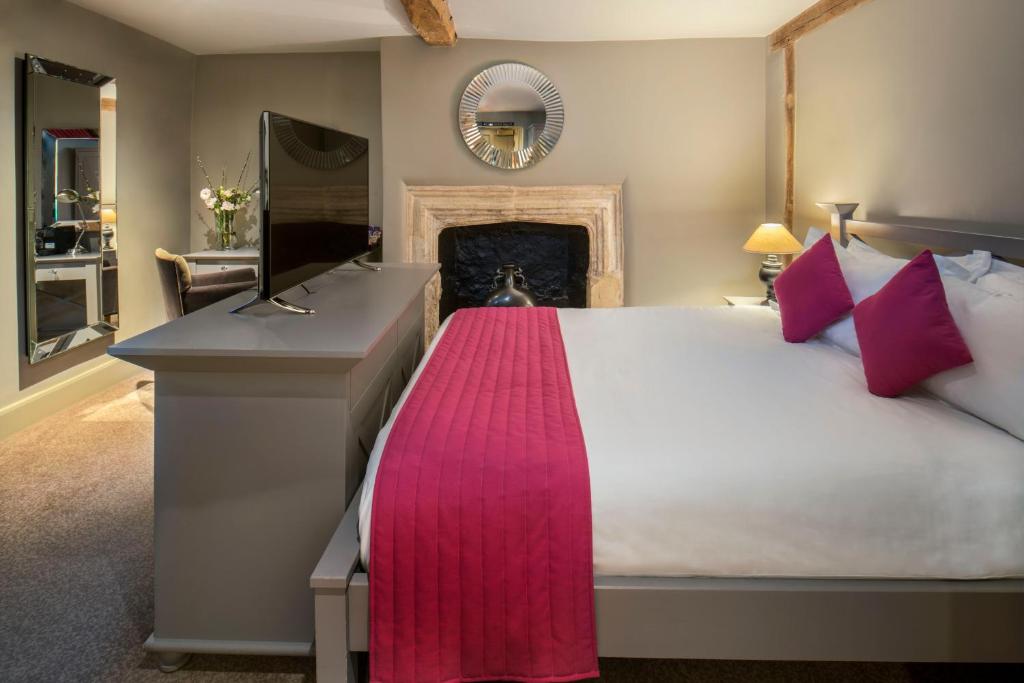 a bedroom with a large bed and a fireplace at Vanbrugh House Hotel in Oxford