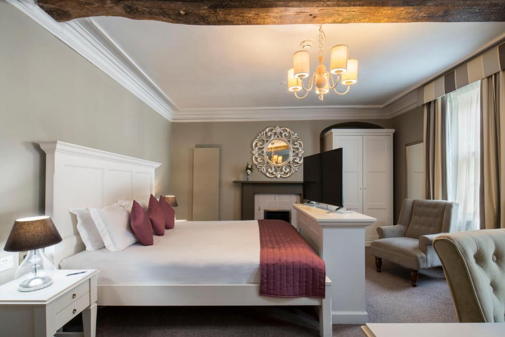 a bedroom with a bed and a desk and a chair at Vanbrugh House Hotel in Oxford