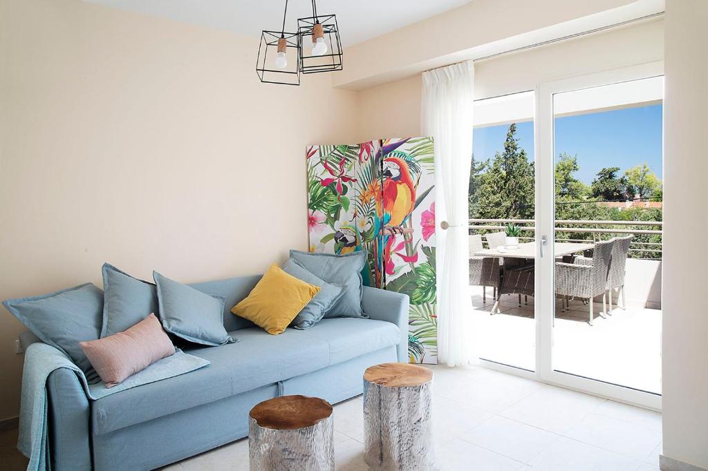 ein blaues Sofa im Wohnzimmer mit Terrasse in der Unterkunft LOTOS - Luxury Apartments in Kounoupidiana