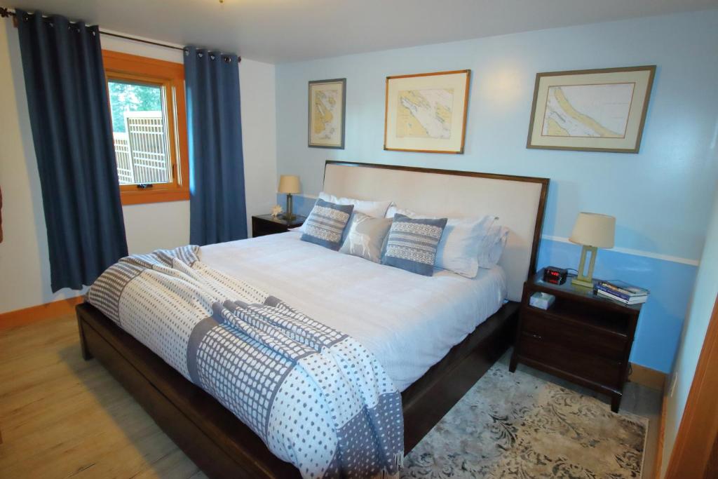 1 dormitorio con 1 cama grande y paredes azules en Mossy Hill Suite en Salt Spring Island