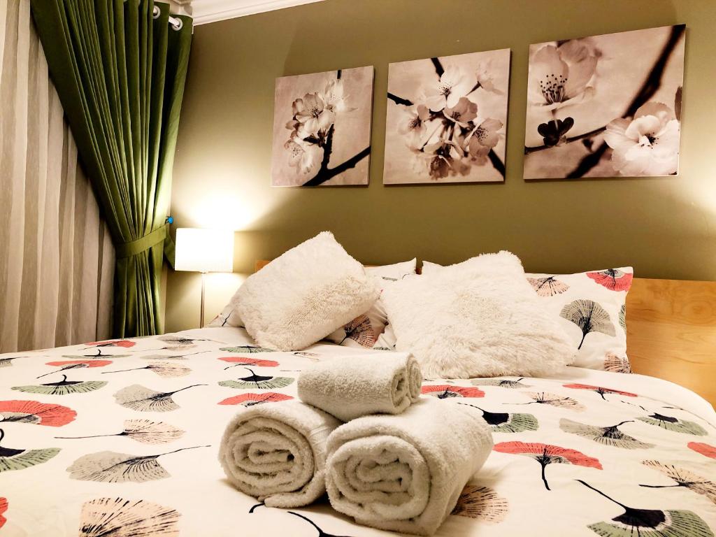 een slaapkamer met een bed met handdoeken erop bij Hannah's Heavenly Home in Surrey