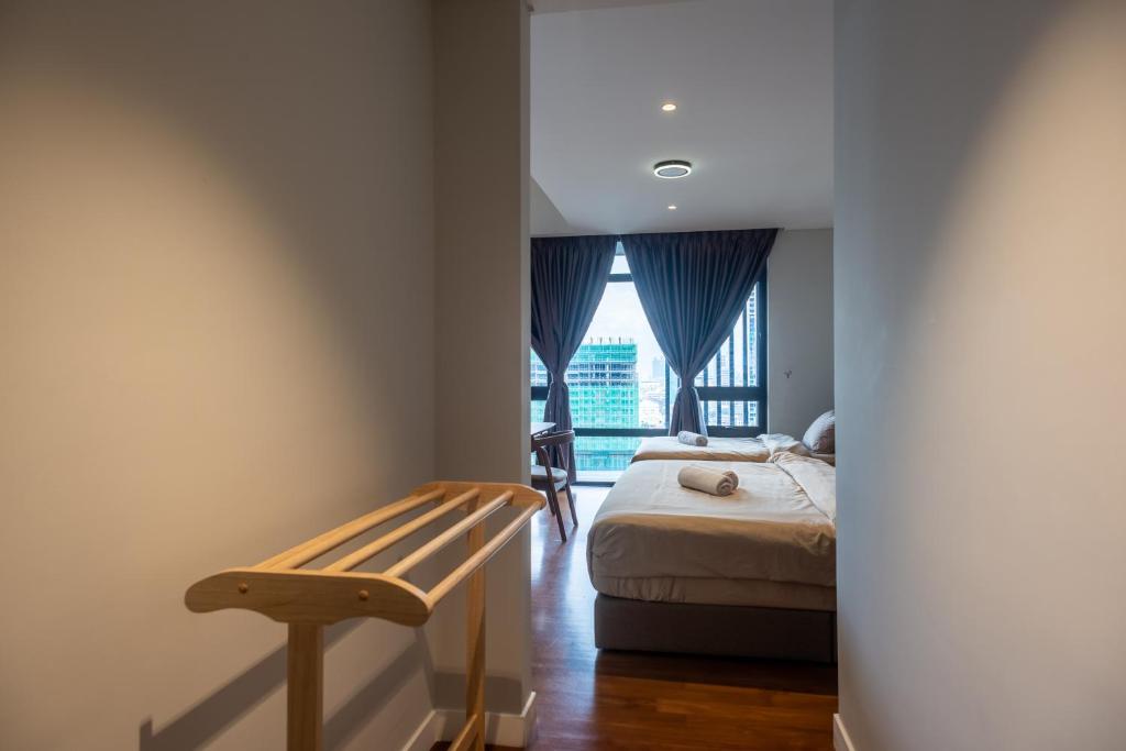 a bedroom with a bed and a bench and a window at Anggun Residences Luxe in Kuala Lumpur
