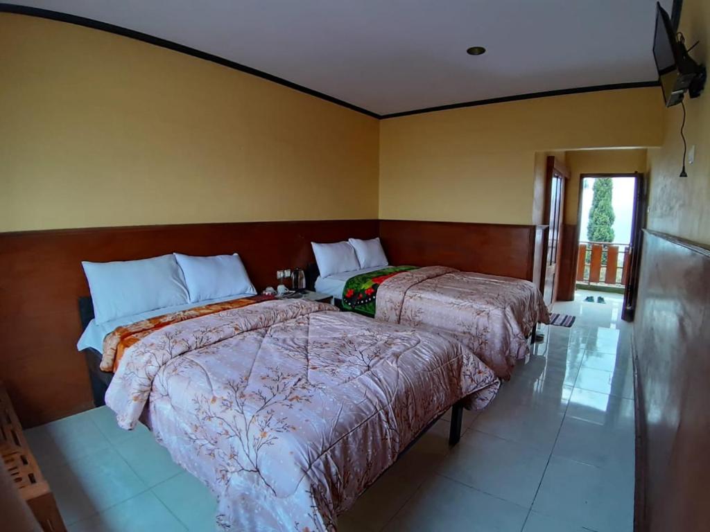 Postel nebo postele na pokoji v ubytování Cemara Indah Hotel