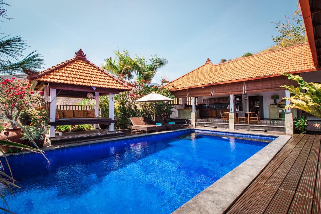 a swimming pool in front of a house at Villa Bukit Malas 3 in Amed