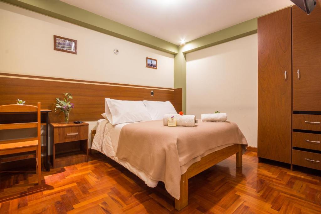 クスコにあるLa Parada Cusco Hotelのベッドとタオル2枚のある寝室