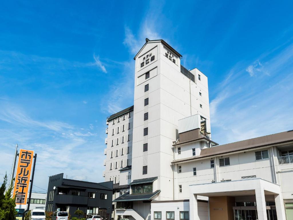 biały budynek z wieżą zegarową na górze w obiekcie Hotel Omiya w mieście Miyako