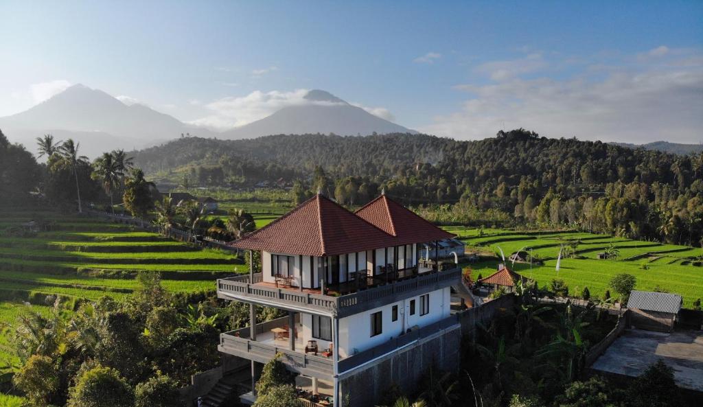 an aerial view of a house with a mountain in the background at Candra Cottage in Munduk