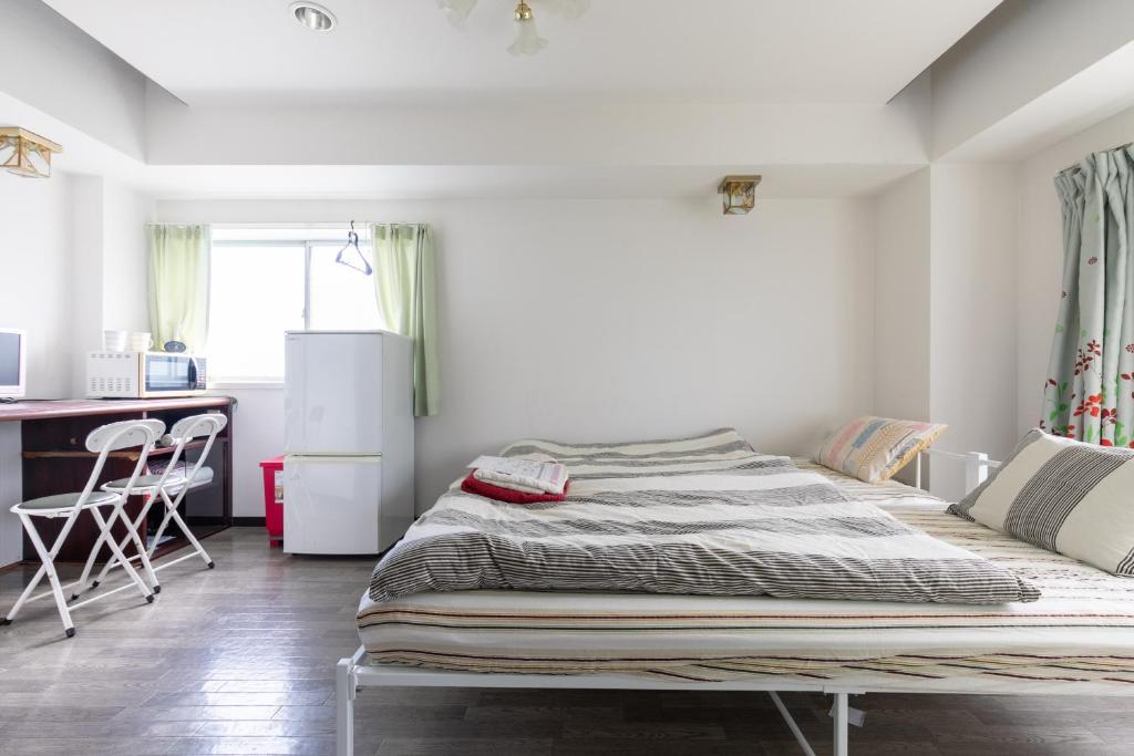 1 dormitorio con 1 cama grande y cocina en Miki Hall Akabane, en Tokio