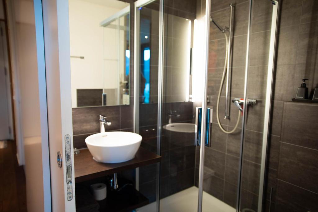 a bathroom with a sink and a glass shower at Luxury loft on top of Villa Wilen with tremendous views by the lake in Sarnen