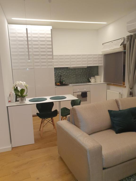 sala de estar con sofá y mesa en Smaragdo apartamentai, en Kaunas