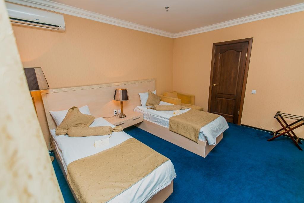 King Hotel Astana tesisinde bir odada yatak veya yataklar