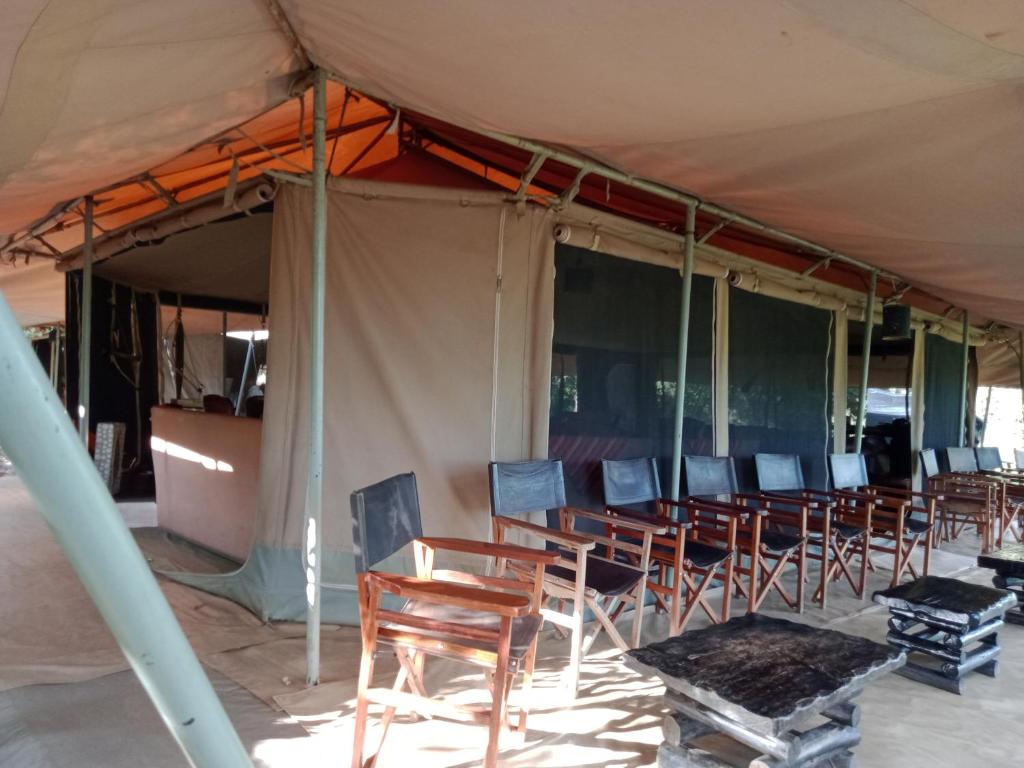 een groep stoelen onder een tent bij Mara Ngenche Safari Camp - Maasai Mara National Reserve in Talek