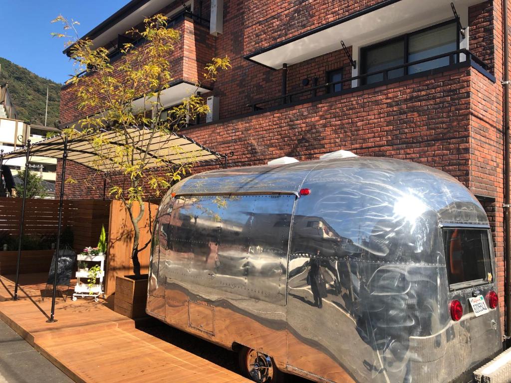 un furgone argentato parcheggiato di fronte a un edificio di mattoni di Condominium MIRAHAKONE a Hakone