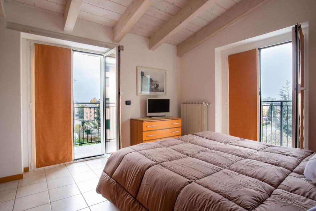 una camera con letto, TV e finestre di Casa Vacanze Valeria a Sondrio