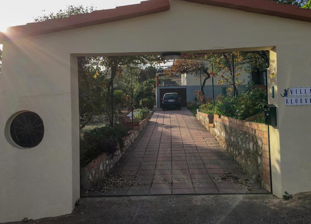 eine Auffahrt, die in ein Haus mit einer Garage führt in der Unterkunft Vakantieverblijf Villa Kluever in Alhaurín de la Torre