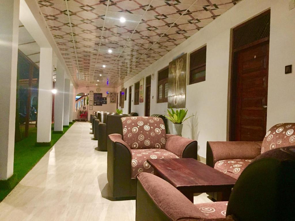 a waiting room with couches and tables in a building at Thisara Guest House in Polonnaruwa