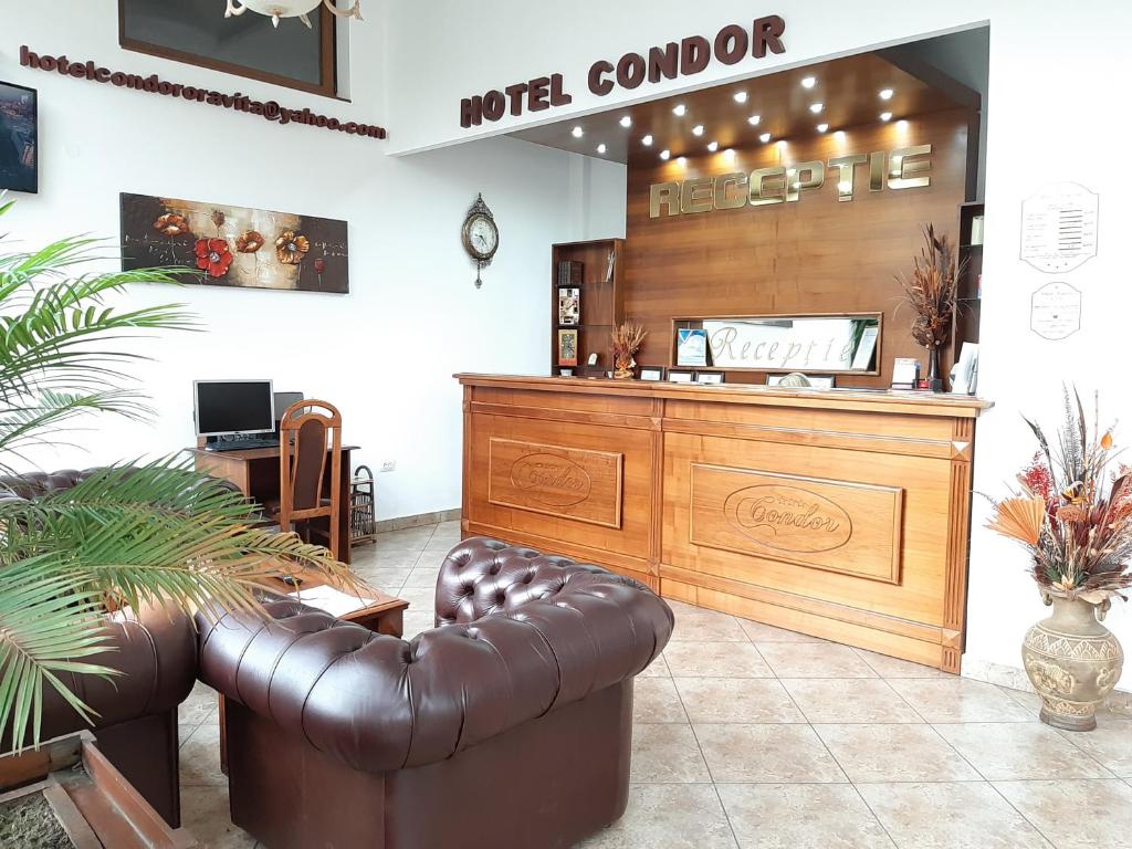 a salon with a leather couch and a counter at Hotel Condor in Oraviţa