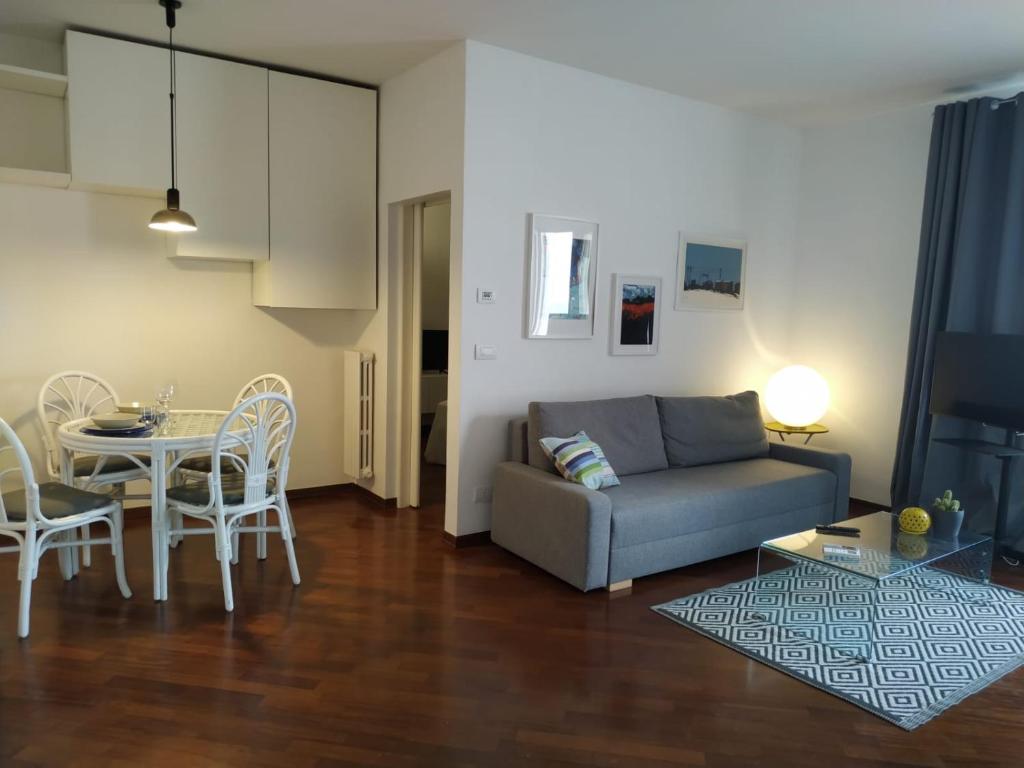 a living room with a couch and a table and chairs at Michi's Home - Attico in Centro in Bari