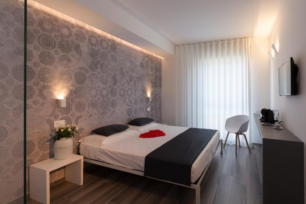 una camera con letto, tavolo e sedia di Hotel Mediterraneo -Spiaggia Ombrelloni e Lettini Inclusi- a Martinsicuro