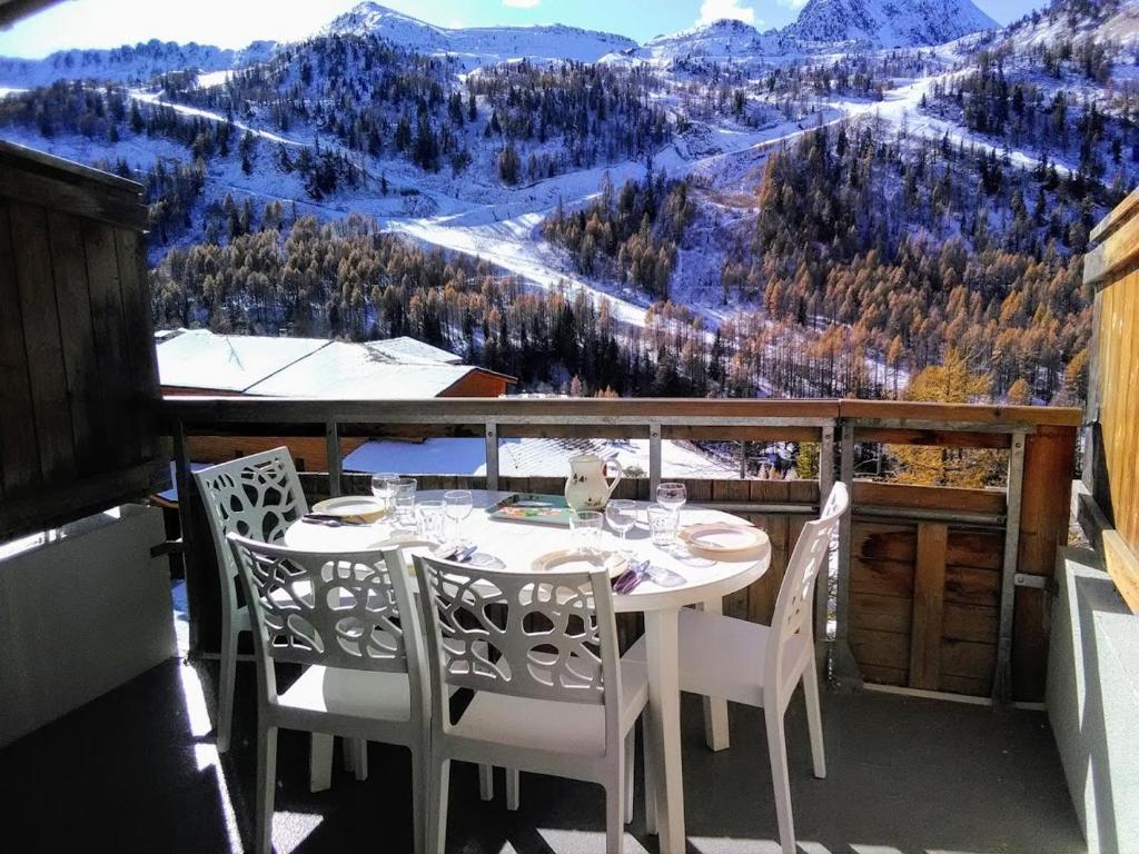 a white table and chairs on a balcony with a view at Les Terrasses d Azur in Isola 2000