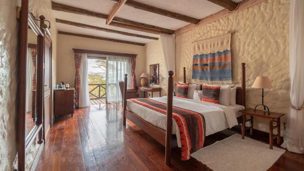 a bedroom with a large bed and a large window at Sarova Lion Hill Game Lodge in Nakuru