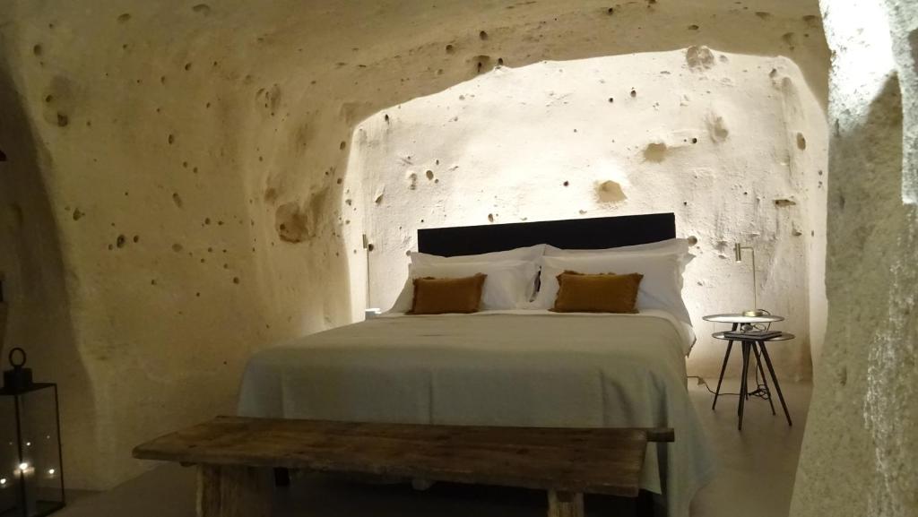 a bedroom with a bed with a concrete wall at StageROOM01 - Matera in Matera