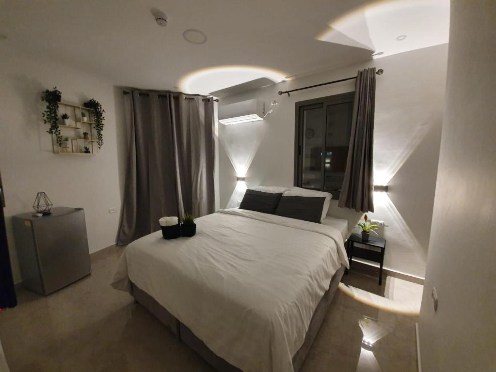 a bedroom with a large white bed and a window at The boutique in Jerusalem