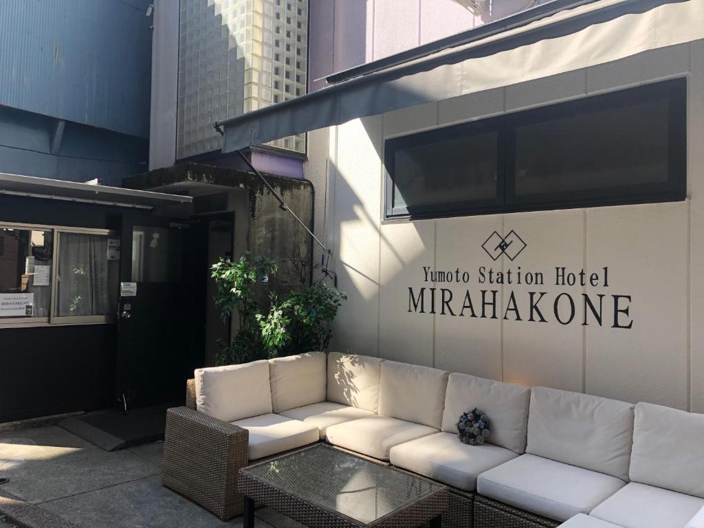 um sofá branco sentado do lado de fora de um hotel Marriott Station em Yumoto Station Hotel MIRAHAKONE em Hakone