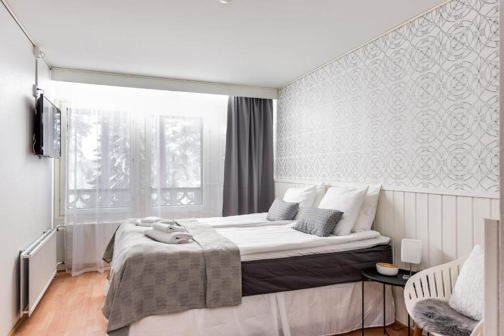 Un dormitorio con una cama grande y una ventana. en Hotel Kajaani, en Kajaani