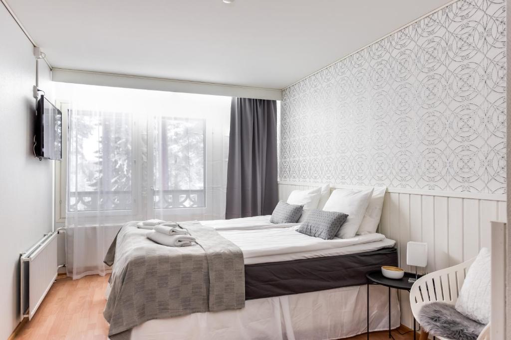um quarto com uma cama grande e uma janela em Hotel Kajaani em Kajaani
