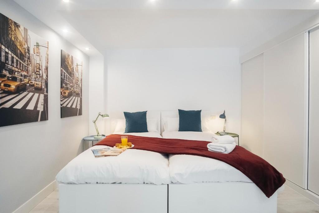 a white bedroom with a large bed in a room at HOMEABOUT RETIRO Apartment II in Madrid