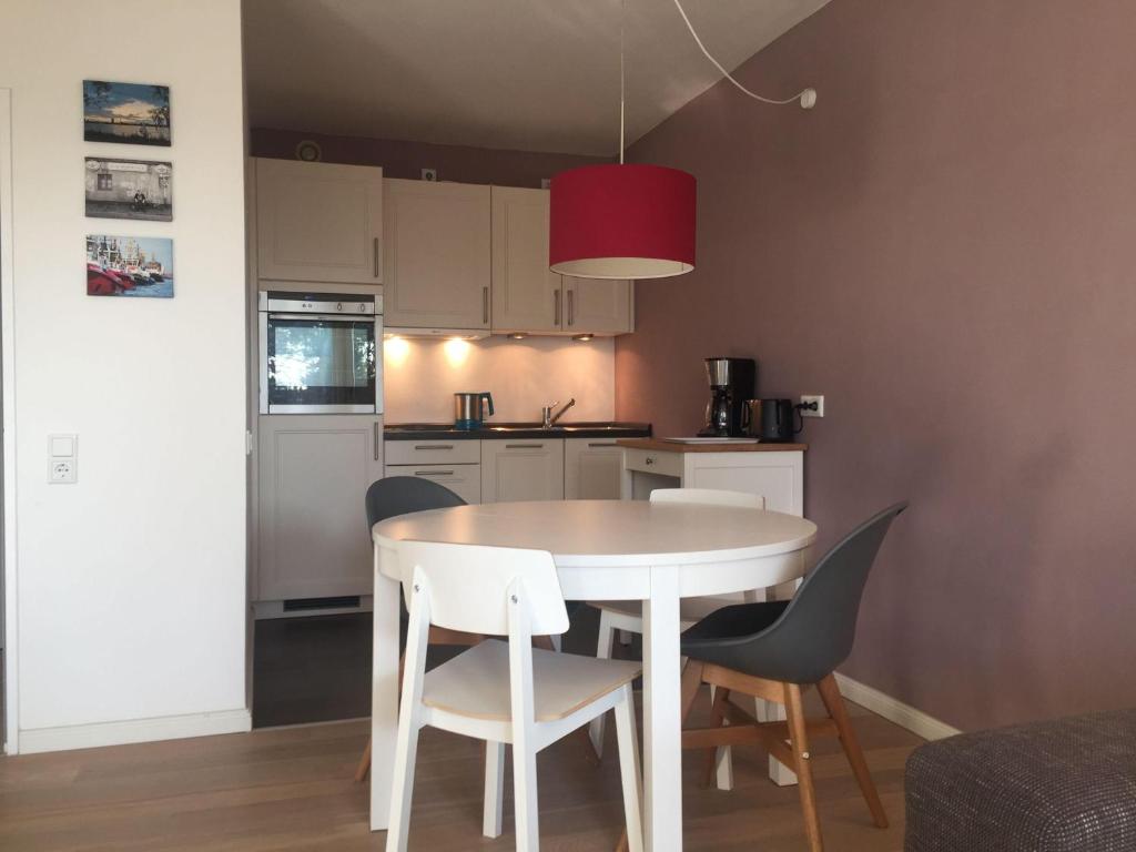 a small kitchen with a white table and chairs at 50-Meter-bis-zum-Strand-Luetje-Loge in Timmendorfer Strand