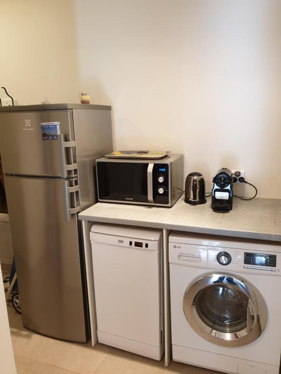 a small kitchen with a microwave and a refrigerator at Rue François Miron in Paris