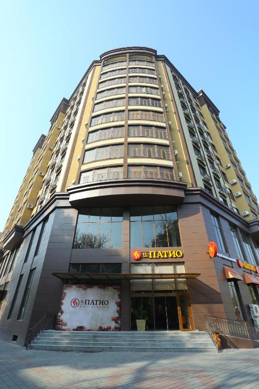 un edificio alto con un cartel delante en Hotel 777 en Dushanbe