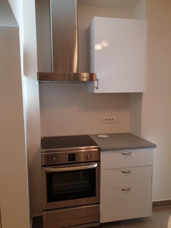 a kitchen with a stove and a white cabinet at Rue François Miron in Paris