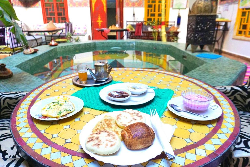 einen Tisch mit Teller mit Lebensmitteln darüber in der Unterkunft Riad Dia in Marrakesch