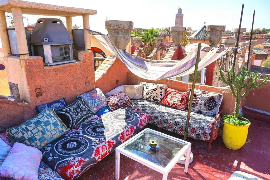 einen Balkon mit einem Sofa und einem Couchtisch in der Unterkunft Hostel Kif-Kif in Marrakesch