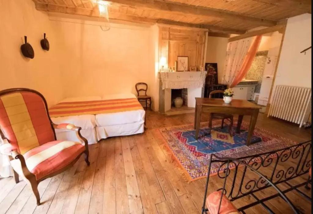 a room with a bed and a table and a chair at Ferme des Prades in Landeyrat